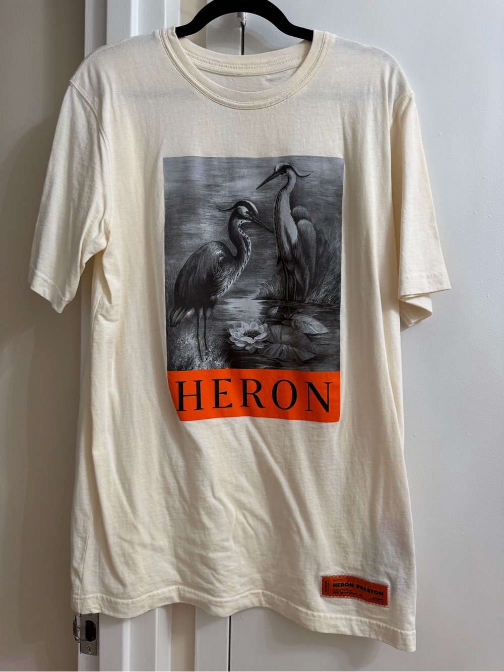 Heron Preston Cream Tee with Orange Woven Brand Tab and Black Care Tag